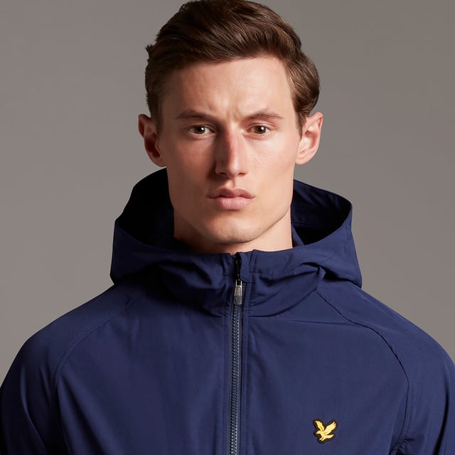 The Lyle & Scott Colourblock Puffer Jacket is all about warmth. Built to handle the cold, you will stay warm and dry in this men's showerproof puffa jacket, constructed with sustainability in mind, from 100% recycled polyester, for ultimate cold weather protection. Keep your hands cosy in the slip pockets and your body warm with the full zip, funnel style neck and padded hood, with adjustable bungee so you can customise the fit for the coldest of days. The colourblock design ensures you don't lose your style, even when you have to cover up.