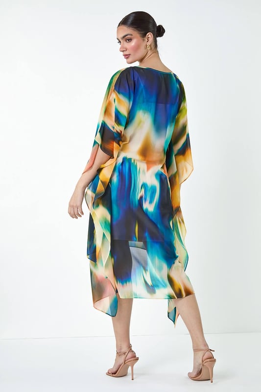 Abstract Print Chiffon Draped Tunic Dress from Roman. Add a touch of elegance to your wardrobe with this Ariella chiffon draped tunic dress. The round neckline and abstract print are complemented by the floaty chiffon draping, creating a flattering dipped hem and cape-style sleeves for a chic look. The stretch jersey inner slip dress lining ensures all-day comfort, while the knee length and adjustable straps in the lining add extra versatility to this piece. Perfect for those Summer wedding invitations, pair with strappy heels and a clutch bag for your next special occasion!