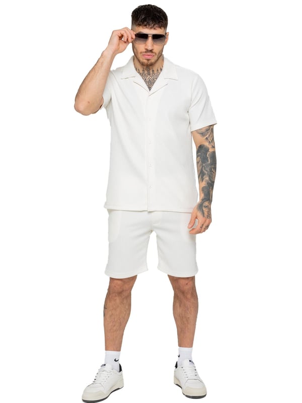 Elevate your summer style with our Enzo Milano Men's Outfit Set, including a textured ribbed revere shirt and relaxed fit shorts. Experience ultimate comfort with a button fastening and adjustable drawstring waistband, while looking effortlessly stylish with a revere collar and single back welt pocket. Made with premium fabric, this set is perfect for any occasion.