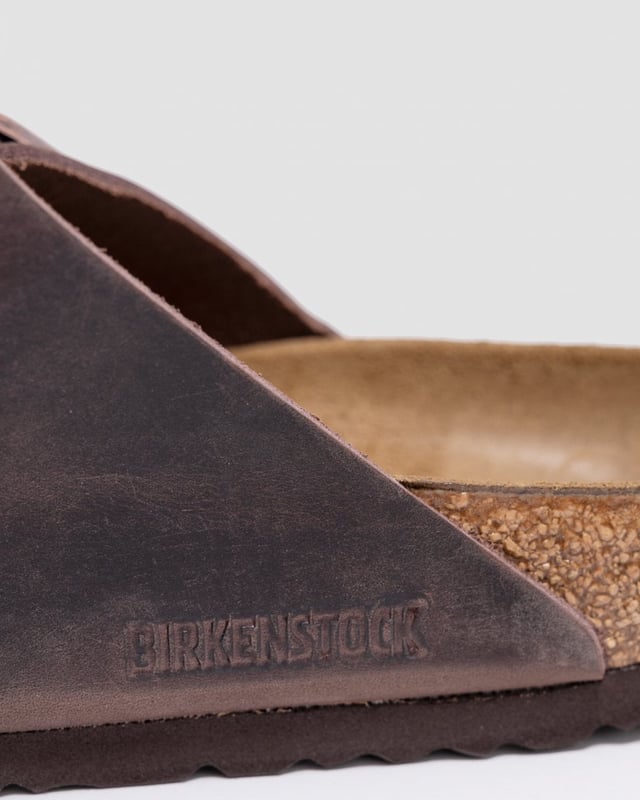 Birkenstock Arizona Habana Unisex Sandals The Birkenstock Arizona SFB Unisex Tabaco Brown Sandals are sandals feature two adjustable straps with metallic buckles that can be customized to fit the foot comfortably.The upper material is made of oiled nubuck leather which is durable and easy to maintain. The leather also has a soft velvety texture that feels comfortable against the skin. The footbed of the Birkenstock Arizona SFB Sandals is made of the brand's signature cork-latex material which is anatomically shaped to support the foot's natural contours. The footbed also has a deep heel cup a roomy toe box and a suede lining that helps wick away moisture keeping the feet cool and dry. The sole of the Birkenstock Arizona SFB Sandals is made of EVA a lightweight and flexible material that provides cushioning and shock absorption.