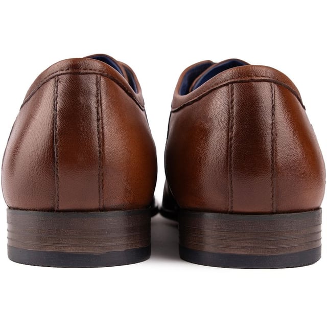 Con un estilo elegante y un diseño elegante. El zapato derby con cordones Bugatti Gibson Toe Cap color canela es imprescindible para el caballero moderno. Con una lujosa parte superior de cuero con el logotipo característico del diseñador. un refuerzo elástico para mayor comodidad y ajuste. Cordones encerados y plantilla acolchada. Estos zapatos son inteligentes sin esfuerzo. Una excelente opción para complementar tu ropa de oficina. traje de negocios o armario de noche.