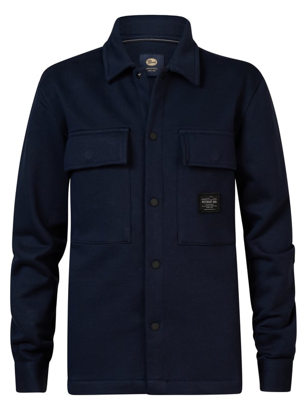 Overshirt aus Sweatstoff mit langen Ärmeln. Dieses Hemd verfügt über einen klassischen Kragen, einen Druckknopfverschluss, zwei Brusttaschen mit Druckknopfverschluss und ein Emblem auf einer Brusttasche. Das Overshirt ist mit Druckknöpfen an den Ärmeln versehen. Haben Sie Schwierigkeiten, sich zwischen zwei Größen zu entscheiden? Dann wählen Sie die größere Größe. Sweatstoff, klassischer Kragen, Druckknopfverschluss, zwei Brusttaschen, 100 % Baumwolle.