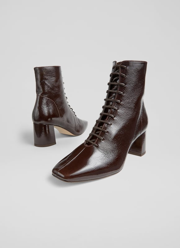 Experience sophistication with every stride. Our Arabella lace-up ankle boots in rich espresso crinkled patent boast a stylish square toe and a sturdy block heel, all exquisitely lined with leather. Perfect for smart-casual ensembles, pair them with tailored trousers or your favourite dress. These lace-up ankle boots are the epitome of style and function. Made in Spain.