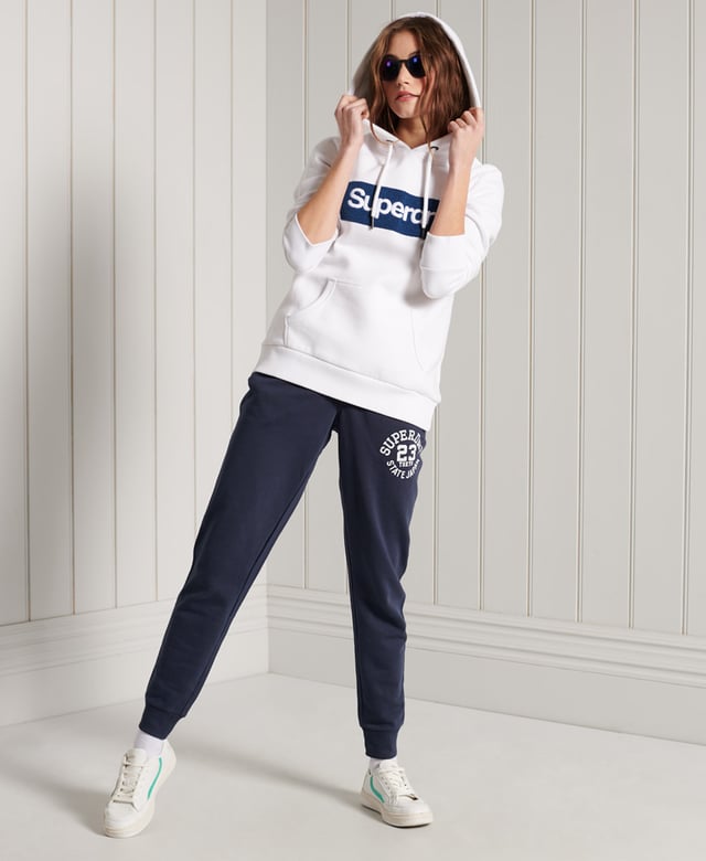 Superdry Core Logo Workwear Hoodie Show your Superdry pride with our Core Logo Workwear Hoodie, featuring a textured logo, soft lining, and a front pouch pocket.Relaxed fit – the classic Superdry fit. Not too slim, not too loose, just right. Go for your normal sizeDrawstring hoodLong sleevesFront pouch pocketRibbed cuffs and hemSoft brushed liningTextured graphic