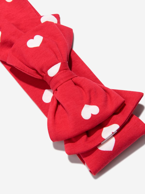 Finish off their look with this pretty red cotton jersey headband by luxury brand, Monnalisa. With a scattering of white hearts this soft and stretchy features a large fixed bow on the front.