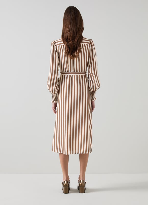 Imagine a breezy afternoon stroll wearing the Emelia candy stripe shirt dress in chocolate and birch. This stylish piece in chocolate and birch silk boasts a classic collar, full length sleeves, and a sophisticated woven stripe design, perfect for smart casual outings. Pair it with elegant flats for a daytime look or enhance it with heels for an evening out.