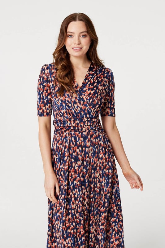 Add a comfortable jersey dress to your wardrobe with this printed midi. It has a v-neck with a faux wrap front, 1/2 sleeves, a flattering ruched waist and a straight midi length skirt. Pair with heels or boots for a go-to style to wear during transitional seasons.