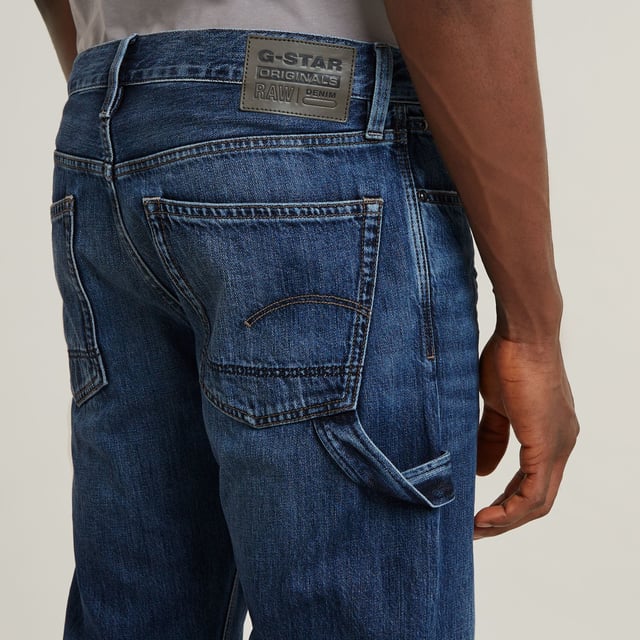 Zip fly. 5 pockets, incl. coin pocket caught in the seam. Tool loop at the side. G-Star RAW label at the back, made from a leather-like paper fabric. Zip & button closure. Mid waist. The Lenney jeans is designed in a straight fit that widens in a bootcut silhouette. The tool loop at the side adds interest. 100% Cotton. Rigid. Weight 11.3 oz. Bootcut