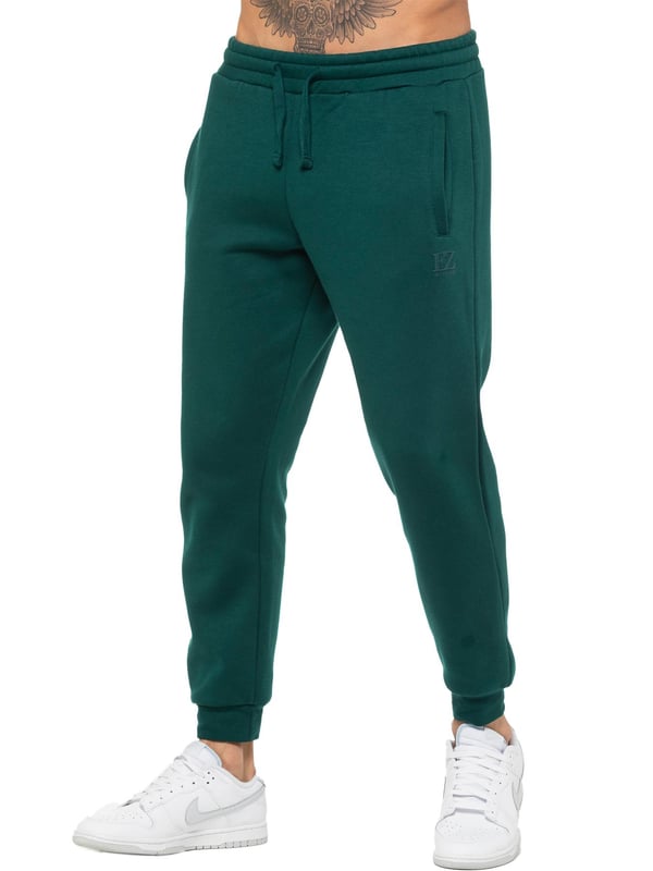 Enzo Mens Regular Fit Joggers. Elasticated Waistband With Adjustable Drawstring. Features 2 Side Slash Pockets & Single Welt Back Pocket. Cuffed Ankle. Features EZ Logo.
