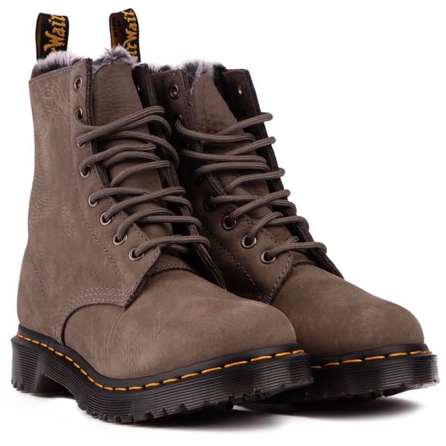 Botas grises con cordones Dr. Martens 1460 Serena para mujer. con una parte superior de cuero. con un sistema de cordones de 8 ojales y la firma AirWair en el talón. Estas botas altas para mujer tienen un suave forro de piel sintética. El inconfundible ADN del DOC como las icónicas costuras amarillas. Marca AirWair y suela Goodyear con amortiguación de aire y banda de rodadura resistente.