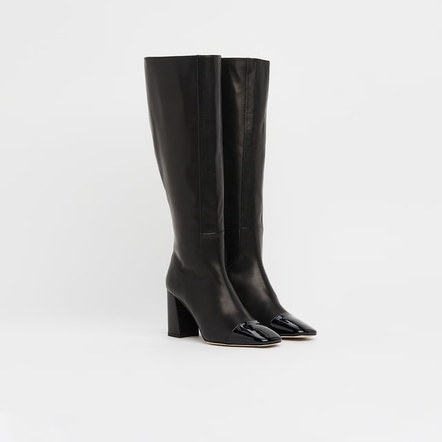 LK Bennett Bess Knee Boots, Black A classic knee boot with a difference, our Bess boots take on the season's toe cap trend. Crafted in Italy from beautifully-soft black calf leather, they have a square toe with a black patent toe cap, seam detail to the front, an inside zip and a leather-covered squared block heel. They're perfect with Sixties-inspired mini dresses and Seventies-style midi dresses.