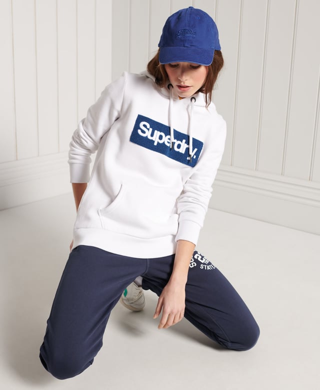 Superdry Core Logo Workwear Hoodie Show your Superdry pride with our Core Logo Workwear Hoodie, featuring a textured logo, soft lining, and a front pouch pocket.Relaxed fit – the classic Superdry fit. Not too slim, not too loose, just right. Go for your normal sizeDrawstring hoodLong sleevesFront pouch pocketRibbed cuffs and hemSoft brushed liningTextured graphic