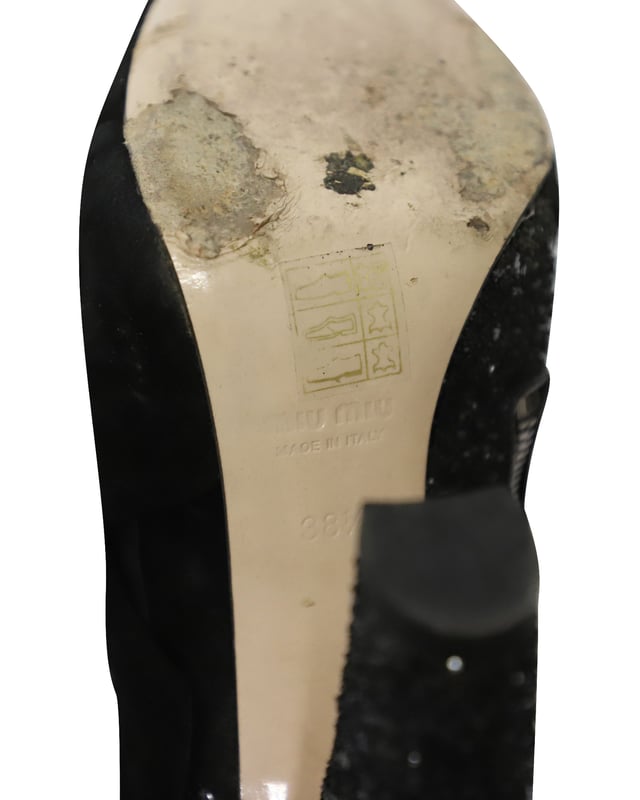 VINTAGE, UVP WIE NEU  
Diese schwarzen Peep-Toe-Stiefeletten von Miu Miu sind aus Wildleder gefertigt und mit Glitter überzogen, um deinen Stil gezielt zu heben. Sie sind mit Reißverschlüssen, Leder-Innensohlen ausgestattet und der Absatz misst 115 mm. Der Wildlederbereich der Schuhe ist so gestaltet, dass er wie ein Band aussieht, was einen zusätzlichen femininen Akzent setzt.

Miu Miu 115mm Glitter-Stiefeletten aus schwarzem Wildleder  
Zustand: Gut  
Nutzungsspuren: Starke Abnutzung an den Sohlen  
Material: Wildleder/Leder  
Größe: 38.5/US8.5  
Absatzhöhe: 115 cm  
SKU: 124358