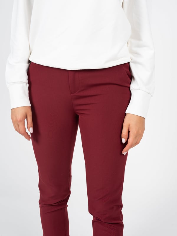 Ajuste a medida que realza la figura y proporciona un aspecto elegante, perfecto tanto para el día a día como para ocasiones más formales.

Abrochados con cremallera y un botón con logo, lo que les da un carácter único y garantiza comodidad y la seguridad de que los pantalones permanecerán en su lugar durante todo el día.

Perneras ligeramente estrechas que ofrecen un look moderno y hacen que los pantalones se combinen bien con diferentes tipos de calzado, desde elegantes zapatillas hasta deportivas sneakers.

La cintura media proporciona confort al llevarlos, al mismo tiempo que acentúa la cintura y añade armonía a la figura.

Con bolsillos laterales, que no solo son prácticos, sino que también añaden un encanto casual a los pantalones, permitiendo almacenar objetos pequeños.

En el bolsillo trasero, un detalle de la marca que destaca sutilmente y añade exclusividad y un carácter único a los pantalones.

Confeccionados con tejido de alta calidad que asegura durabilidad, comodidad y un aspecto elegante, lo que hace que los pantalones sean una prenda de larga duración.