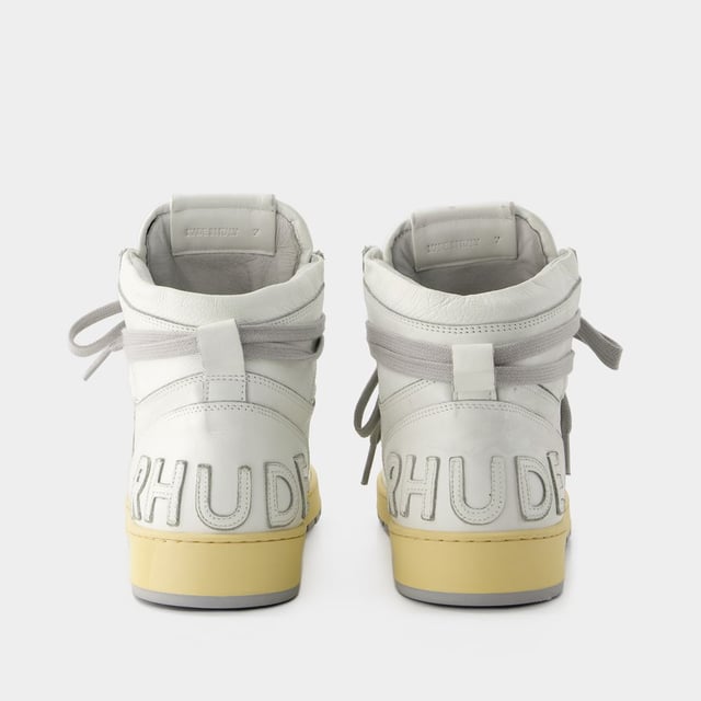 Presentamos las zapatillas Rhecess de Rhude, donde la frescura urbana se une a la comodidad contemporánea. Estas zapatillas fusionan a la perfección un diseño moderno con un guiño al estilo streetwear, mostrando una silueta única perfecta para ir a la moda statement. Para elevar tu look con estas zapatillas statement, considéralas la base de un conjunto moderno de inspiración callejera. Combínalas con unos vaqueros desgastados, una sudadera con capucha de estampado gráfico y unas gafas de sol atrevidas para conseguir un look vanguardista sin esfuerzo, perfecto para un día con amigos o una noche informal en la ciudad. Rhude Las zapatillas Rhecess de brand ejemplifican el compromiso de la marca con la calidad y la moda, ofreciéndote una opción de calzado distintiva y versátil que combina sin esfuerzo el encanto moderno con el estilo urbano. Sal con confianza, mostrando tu sensibilidad única por la moda y tu estilo de entrenador contemporáneo. Colores: Blanco - Blanco/Blanco. Material principal: piel de ternero lisa. Material de la suela: caucho. Material del forro: algodón. Cierre: cordones en la parte superior. Forma de la punta: almendra. Ajuste: fiel a la talla - Talla: