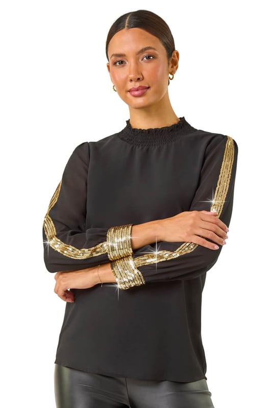 Sequin Stripe High Neck Sleeve Top from Roman. Make a sparkling statement in this elegant high neck sleeve top. Adorned with a glitzy gold sequin stripe running down the sleeve, finished with a dazzling sequin cuff. The long sleeves and high neck add sophistication to this top, making it perfect for the Autumn/Winter season. Pair with tailored trousers and heels for a stylish evening look that will surely turn heads!