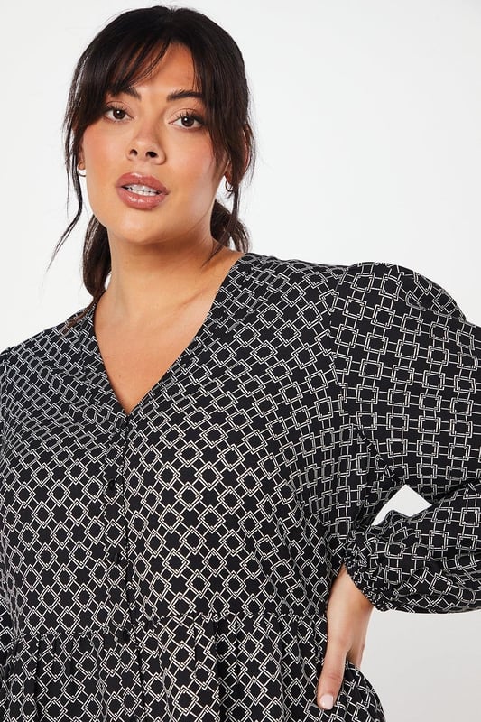 Striking geometric print for a modern, eye-catching look
        Button-through front design for easy wear and versatility
        Flattering peplum silhouette to accentuate the waist
        Voluminous long sleeves for a touch of drama
        V-neckline to elongate the neck and add a feminine touch
    
    This Dorothy Perkins peplum top radiates contemporary charm with its captivating geometric print. The button-through design offers both style and practicality, allowing for effortless dressing and the option to adjust your look. The peplum silhouette gracefully cinches at the waist before flaring out, creating a flattering shape for various body types. Style this versatile piece with slim-fit trousers and white trainers for a chic daytime ensemble perfect for brunching with friends or attending a casual family gathering. For a more polished look, pair it with dark tailored trousers and ballet flats, ideal for those days when you want to feel put-together without compromising on comfort. The long, billowy sleeves add a touch of drama, making this top a standout choice for your wardrobe that transitions seamlessly from day to night.