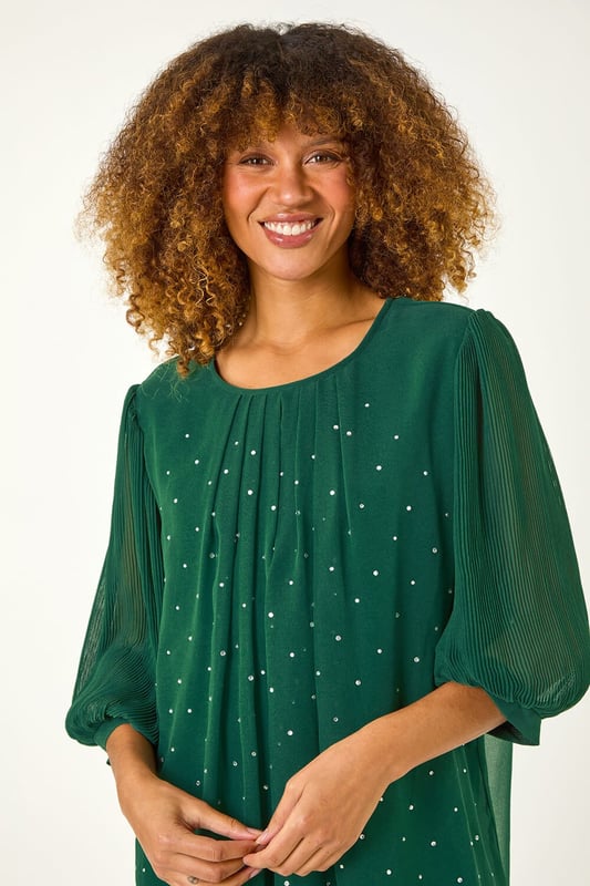 Pleated Sleeve Hotfix Detail Top from Roman. Add a touch of glamour to your Autumn/Winter wardrobe with this chic pleated sleeve top. The stylish round neck and elegant gathering at the neckline perfectly complement the eye catching all over hotfix detailing. The 3/4 pleated sleeves add a feminine touch to this versatile top. Pair it with pleather trousers and heeled boots for a party ready look that's sure to make a statement!