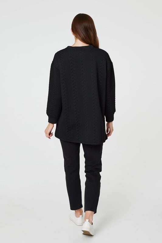 Get cosy in this cable knit oversized jumper. It has a round neck, long sleeves, an oversized longline shape and a thigh length hem. Pair with jeans or leggings for a classic style you can keep in your capsule closet for years to come.