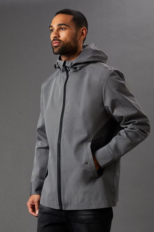 Water-resistant fabric for protection against light rain
        Adjustable hood for customisable coverage
        Full-length zip closure for easy wear
        Practical side pockets for essentials
        Versatile design suitable for various casual occasions
    
    This Burton water-resistant hooded jacket is the perfect companion for the unpredictable British weather. Its sleek design marries functionality with style, making it an ideal choice for the modern man who values both practicality and appearance. The jacket's clean lines and minimalist aesthetic allow for effortless pairing with a variety of outfits. For a smart-casual look, layer it over a light jumper with dark jeans and trainers, as shown in the image. It's equally at home for a weekend walk in the park, a casual day at the office, or meeting mates at the local pub. The adjustable hood and water-resistant fabric offer protection from unexpected showers, ensuring you stay dry and comfortable. Whether you're heading to a football match or running errands around town, this versatile jacket will keep you looking sharp and prepared for whatever the day may bring.