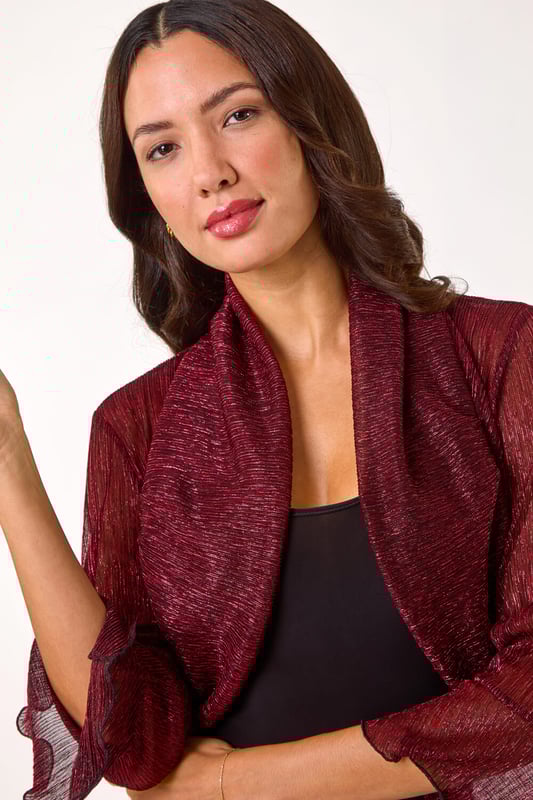 Plisse Jersey Bolero from Roman. Add a touch of glamour to your outfit with this chic bolero. Crafted from a shimmering metallic jersey plisse fabric, this cropped bolero features elegant 3/4 fluted sleeves and an edge to edge design. The bolero shape is perfect for layering over a simple t-shirt and jeans to instantly elevate your look. Perfect for Autumn/Winter, this piece is a must-have for adding a touch of sparkle to your wardrobe!