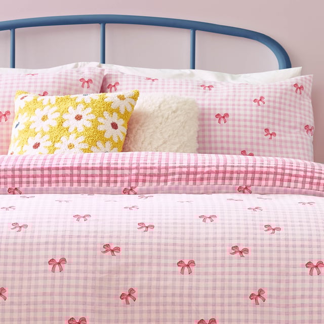Brighten up your bedroom with the Gingham Bows Checked Duvet Cover Set, a perfect blend of classic charm and contemporary playfulness. Featuring a timeless gingham pattern adorned with delicate bows, this set adds a subtle yet striking detail to your space. The reversible design, with a small-scale check on the reverse side, offers effortless versatility, giving you two stylish looks in one. Crafted from a durable polycotton blend, it promises a soft touch, easy care, and a relaxed finish. Elevate your home with a piece that combines trending design with timeless charm, perfect for creating a cosy yet refined retreat.