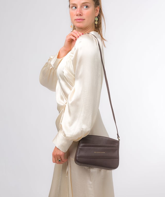 The 'Helena' cross body bag from the Pure Luxuries Marylebone collection is handcrafted from high-quality, genuine Nappa leather with a natural super-soft touch. The zip-over top opens to reveal a 100% cotton-lined interior. The spacious compartment features two slip pockets to help maintain an organised bag. A zipped pocket on the front of the bag provides on-the-go storage. Features gold-coloured metal fittings and zips alongside the adjustable slim leather strap, with a maximum drop length of 65cm. The Pure Luxuries logo is embossed in gold foil for a beautifully simple finishing touch.