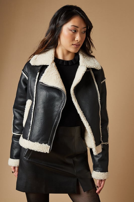 Striking contrast borg detailing for added warmth and style
        Asymmetrical zip front closure for a modern edge
        Oversized collar for a bold, fashion-forward look
        Cropped length perfect for layering
        Versatile design suitable for various casual occasions
    
    This PU borg detail collared zip jacket from Oasis is the epitome of cool-weather chic. The contrasting borg lining not only adds a cosy touch but also creates a striking visual appeal. Its asymmetrical zip closure and oversized collar lend a contemporary edge to your ensemble. The cropped silhouette is ideal for showcasing high-waisted bottoms, as demonstrated by the model pairing it with wide-leg trousers. For a casual day out, style it with your favourite jeans and trainers. Alternatively, dress it up for an evening with friends by layering it over a fitted dress and ankle boots. This jacket is a versatile piece that will quickly become a go-to in your autumn and winter wardrobe, perfect for family gatherings, weekend brunches, or casual outings where you want to make a stylish statement without compromising on comfort.