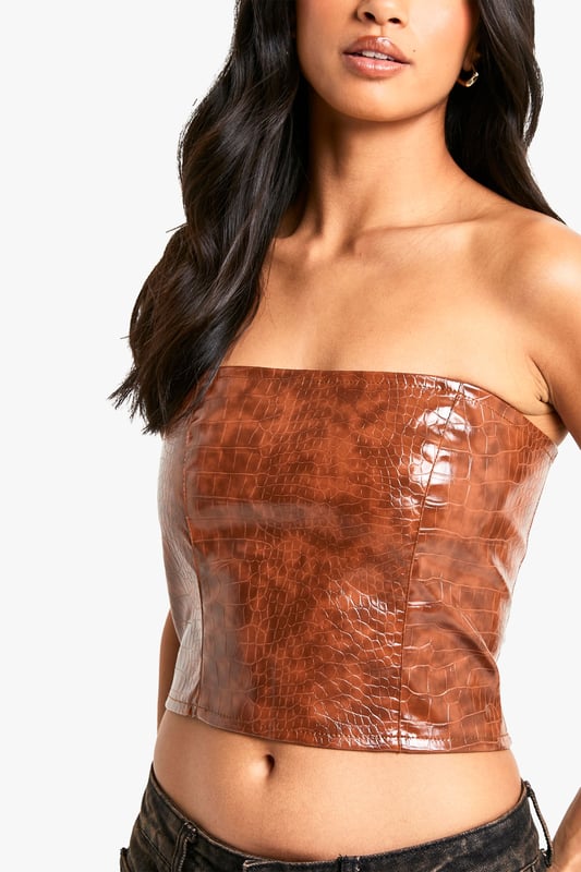 Petite Croc Look Faux Leather Bandeau Corset Top Gain some serious style points this season in this petite top. Cut shorter to ensure the perfect fit, our tops for petite women are designed for queens 5'3'' and below. From petite t-shirts to petite blouses, we've got all the new-season styles you need in your wardrobe. Feeling casual? Dress it down with a pair of straight leg jeans and chunky trainers. If out out is more your vibe, team with some distressed hem shorts and killer heels for a major style statement. Style: CorsetFabric: PUNeckline: Bandeau