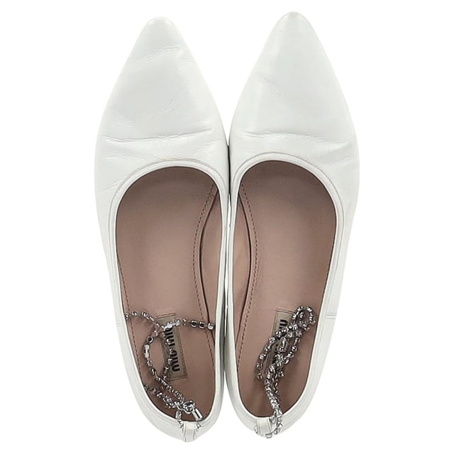 Empfohlener Verkaufspreis
Veredeln Sie Ihren Stil mit den Miu Miu Ballerinas mit verziertem Riemen und spitzer Zehenpartie aus makellosem weißem Leder. Diese atemberaubenden Ballerinas bestechen durch ihre elegante spitze Zehenpartie und den zart verzierten Riemen, der jedem Outfit einen Hauch von Glamour verleiht. Gefertigt aus hochwertigem Leder bieten sie Komfort und Eleganz und eignen sich perfekt für den Tag und Abend. Ob zu einer maßgeschneiderten Hose oder einem fließenden Kleid – diese Ballerinas sind der Inbegriff moderner Eleganz. Zeigen Sie sich selbstbewusst und setzen Sie ein Statement mit diesen exquisiten Miu Miu Ballerinas.

Miu Miu Ballerinas mit verziertem Riemen und spitzer Zehenpartie aus weißem Leder

Zustand: Gut
Gebrauchsspuren: Leichte Gebrauchsspuren, Flecken und Knicke an der Oberfläche.
Verpackung: Keine
Farbe: Weiß
Material: Leder | Leder
Größe: EU 37,5/UK 4,5/US 7,5
Maße: Innensohlenlänge: 290
Artikelnummer: NAPPUGBSH398054W