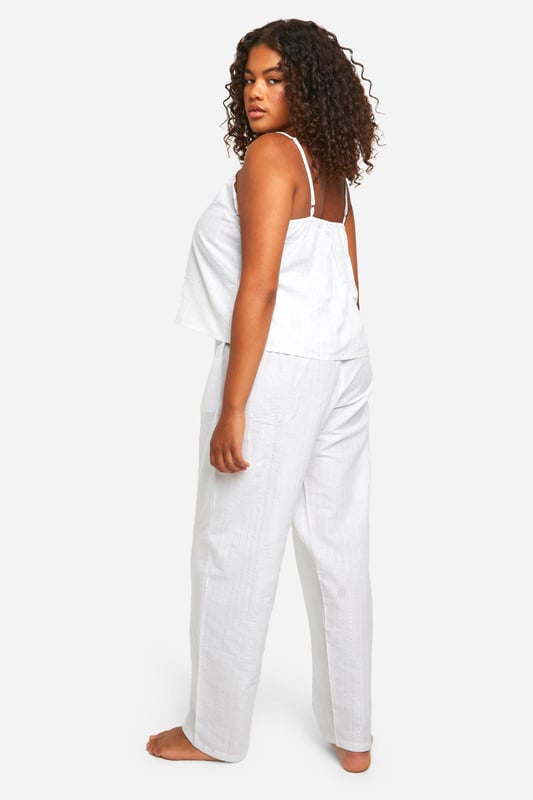 Chic pinstripe pattern for a classic look
        Comfortable cami top with delicate lace trim
        Wide-leg trousers for ultimate relaxation
        Adjustable spaghetti straps for a perfect fit
        Lightweight fabric ideal for year-round wear
    
    Indulge in the perfect blend of comfort and style with this charming plus-size pyjama set. The pinstripe pattern adds a touch of sophistication to your nighttime routine, whilst the soft fabric ensures a cosy night's sleep. The cami top features a flattering lace trim and adjustable straps, allowing you to customise the fit to your liking. Pair it with the wide-leg trousers for a relaxed silhouette that's perfect for lounging. Whether you're settling in for a movie night or enjoying a lazy weekend morning, this versatile set is your go-to choice. The lightweight fabric makes it suitable for all seasons, keeping you cool in summer and comfortably warm in winter. Embrace the effortless chic of this pyjama set and transform your nightwear collection.