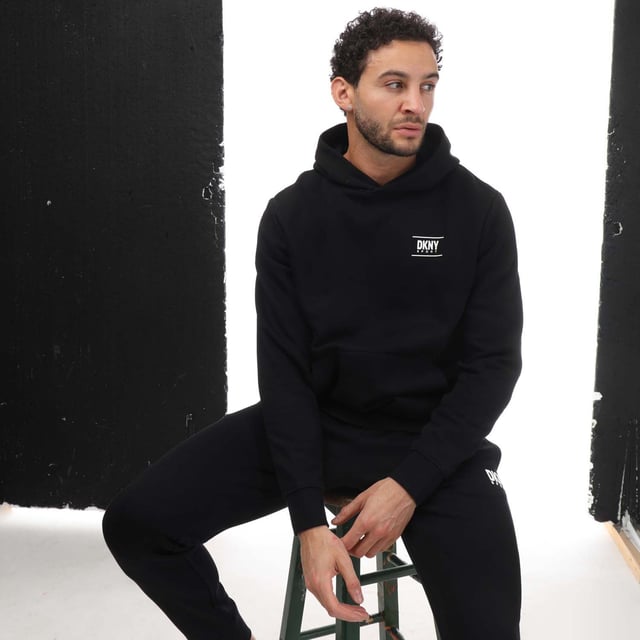 Mens DKNY Printed Logo Blackwater Hoodie in black.- Adjustable drawstring hood.- Kangaroo pocket.- Ribbed cuffs and hem.- Loose fit.- 72% Cotton  28% Polyester.- Ref: DKS0122BLK