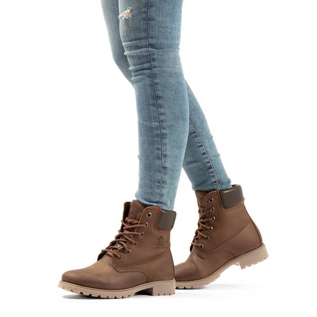 Steigen Sie mit Stil und Komfort aus mit Panama Jack-Stiefeln. Egal, ob Sie über schroffe Landwege wandern oder durch städtische Straßen navigieren, der originale Panama Jack 03 B168 Damen-Schnürstiefel ist Ihr perfekter Begleiter. Diese Stiefel zeichnen sich durch ein klassisches Design mit einer schlichten runden Spitze und einem dunkelbraunen, gepolsterten Lederkragen aus und strahlen zeitlose Eleganz aus. Die genähte Commando-Sohle sorgt für Haltbarkeit und Stabilität auf jedem Gelände. Die braunen Panama Jack 03 Schnürstiefeletten für Damen sind so konzipiert, dass sie den Elementen standhalten. Mit einem wasserdichten, glatten Nubuk-Obermaterial, einem weich gepolsterten Knöchelschaft und einem warmen Futter halten diese Stiefel Ihre Füße kuschelig und trocken. Das geprägte Logo an der Ferse und die silbernen sechseckigen Metallösen verleihen ihrem robusten Charme einen Hauch von Raffinesse. Hauptmerkmale: Klassisches Design: Die Panama 03-Stiefel vereinen Design, Qualität und Komfort nahtlos und bieten eine zeitlose Ästhetik für Männer und Frauen. Vielseitiger Tragekomfort: Egal, ob Sie die Straßen der Stadt erkunden oder Bergpfade erobern, diese Stiefel sind perfekt für alle Ihre täglichen Abenteuer. Wasserdichte Konstruktion: Diese Stiefel sind aus wasserdichtem Vintage-Nappaleder mit Lederfutter gefertigt und sorgen dafür, dass Ihre Füße bei jedem Wetter trocken und bequem bleiben. Anatomische Unterstützung: Genießen Sie verbesserten Komfort und Hygiene mit der anatomisch geformten Innensohle, die eine perfekte Passform für Ihre Füße bietet. Langlebig und rutschfest: Die Gummiaußensohle bietet Flexibilität, Haltbarkeit und rutschfeste Traktion und sorgt für Stabilität auf verschiedenen Oberflächen. Hergestellt in Spanien: Mit einer Schafthöhe von 18 cm werden diese Stiefel fachmännisch in Spanien gefertigt, um höchste Handwerkskunst und Qualität zu gewährleisten. Schlüpfen Sie in die Stiefel von Panama Jack und erleben Sie die perfekte Mischung aus Stil, Haltbarkeit und Komfort für Ihre alltäglichen Abenteuer. Diese Stiefel wurden für alle entwickelt, die Wert auf Qualität und Handwerkskunst legen und sind Ihr vertrauenswürdiger Begleiter, wohin auch immer Ihre Reise Sie führt
