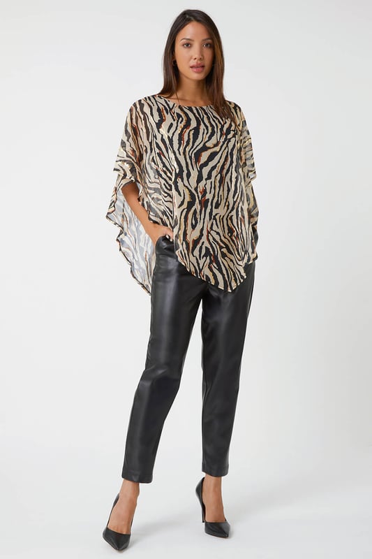 Animal Foil Overlay Stretch Top from Roman. Take a walk on the wild side with this luxurious zebra print party top. Designed with an asymmetrical chiffon overlay that features shimmering foil print, this style is sure to turn heads at your next special occasion. This pull on style has a soft stretch jersey lining for maximum comfort as well as a classic round neckline and short sleeves. Wear with faux leather trousers and heeled boots for style that screams Winter glamour.