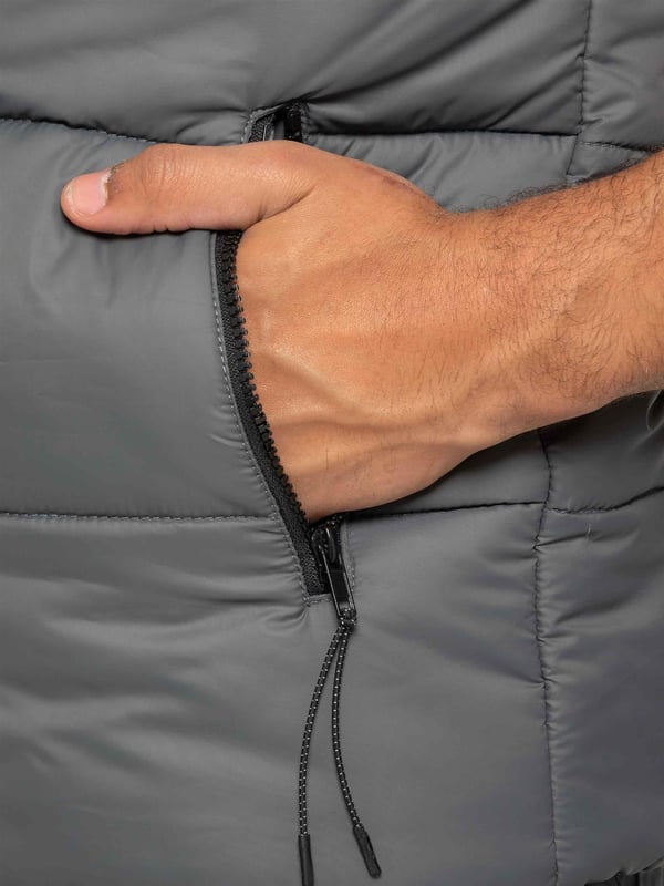 Embodying both fashion and function, the Enzo Mens Puffer Gilet boasts a water-resistant design and a high neck for added warmth. It also offers secure storage with zipped side pockets, and a custom fit with its elasticated hem and adjustable toggle. The full zip-up front and lined interior provide ultimate comfort and practicality. With a EZ branded badge on the chest, this gilet is crafted from durable 100% polyester and is conveniently machine washable.