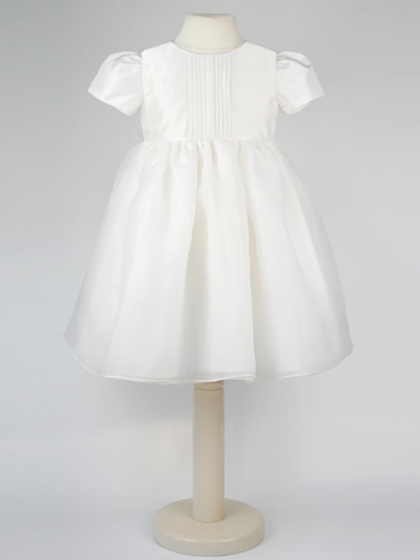 Perfect for Flower Girls, Bridesmaids or Special occasion!
'Dolly' evolved from one of our most popular dresses.

It has been beautifully re-designed to include our pin tuck detailed front, button back and gorgeous puffed sleeves to create the prettiest of dresses that is as comfortable as it is fun. Team it with a sash, ribbon or flower in any colour to match your colour scheme.

You'll find all our dresses are lined in cotton lawn for extra softness and perfect for sensitive skin.

The dress will arrive with you on a Satin padded hanger and covered in one of our Heritage garment protector bags for safe keeping.

Outer - 100% Mock Silk polyester fabric and trims

Lining - 100% cotton

Dry Clean or Hand Wash