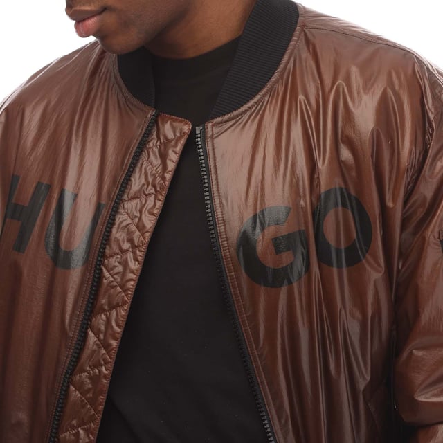 Mens HUGO Byler2431 Jacket in brown.- Ribbed bomber style collar.- Branded full front zip opening.- Two press stud entry pockets.- Zip entry pocket situated on the upper left sleeve.- Signature HUGO logo is printed on the chest.- All over padded design.- Ribbed cuffs and hem.- 100% Polyamide.- Ref: 50521233890