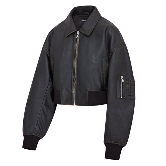 Mejora tu estilo con esta cazadora bomber de piel negra, sencilla y moderna. Diseñada para un look boyfriend relajado y oversize, esta prenda está confeccionada en suave piel de napa de oveja, con costuras y bolsillos envejecidos por expertos para un aspecto vintage. Una robusta cremallera YKK da lugar a un cuello clásico estilo camisa, mientras que el dobladillo y los puños de punto elástico garantizan un ajuste ceñido y calidez. Con dos bolsillos en la cintura y un bolsillo en la manga con cremallera, además de un lujoso forro de satén con un bolsillo interior con ribete de piel, esta cazadora combina funcionalidad con una sofisticación vanguardista. Piel de napa de oveja envejecida suave, corte oversize, cremallera YKK gruesa, dobladillo y puños de punto elástico, forro de satén con bolsillo interior con ribete de piel