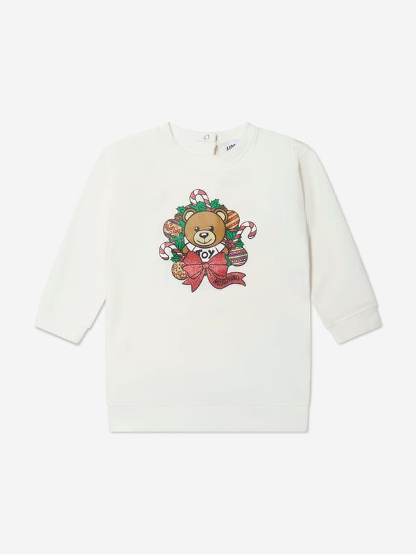 Moschino depict high quality construction in their eccentric designs. This baby girls cloud dress captures the Italian label's superior craftsmanship and fun outlook. Made with 'Moschino' teddy bear holiday print on the front with ribbed trims. She will look and feel divine. ‚ Moschino Teddy Bear Holiday Print ‚ Round Neck‚ Long Sleeves‚ Press-Stud Fastening At the Back‚ Fabric: 95% Cotton, 5% Elastane‚ Hand-WashingMoschino : Baby Height1-3M: 21" / 54cm3-6M: 23.6" / 60cm6-9M: 26.3" / 67cm9-12M: 29.1" / 74cm12-18M: 31.5" / 80cm18-24M: 33.8" / 86cm2Y: 36.2" / 92cm3Y: 38.6" / 98cm