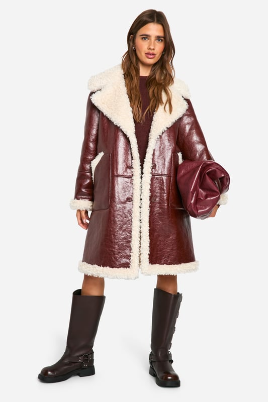 Long-line aviator style jacket with contrasting teddy lining
        Oversized notched collar for dramatic flair
        Plush faux fur trim along edges and cuffs
        Side pockets for practicality and warmth
        Durable PU outer for a leather-like appearance
    
    Make a bold statement this season with our striking long-line aviator jacket. This eye-catching piece combines the rugged charm of a classic flight jacket with the cosy comfort of teddy lining, perfect for braving the British chill in style. The oversized collar and plush trim add a touch of drama to your ensemble, while the durable PU outer ensures longevity. Style it as seen with a mini dress and chunky boots for an edgy, street-smart look that's ideal for casual outings or laid-back gatherings. Alternatively, layer it over jeans and a jumper for a more relaxed weekend vibe. This versatile jacket effortlessly bridges the gap between fashion-forward and functional, making it a must-have addition to your autumn/winter wardrobe.