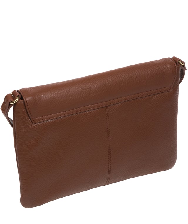 This stylish, sleek and spacious cross body bag from Pure Luxuries London's Marylebone Collection is a gem of a bag. The 'Ruby' features a fold-over top secured with a magnetic press-stud opens to reveal a 100% cotton lined interior and features three slip pockets concealed - ideal for all your essentials. The accessory is adorned with a slim and adjustable leather strap with a drop leather of 65cm. The design is finished with attractive gold-coloured metal fittings and zips which are a luxurious addition alongside the blind embossed Pure Luxuries logo which is a sophisticated finishing touch