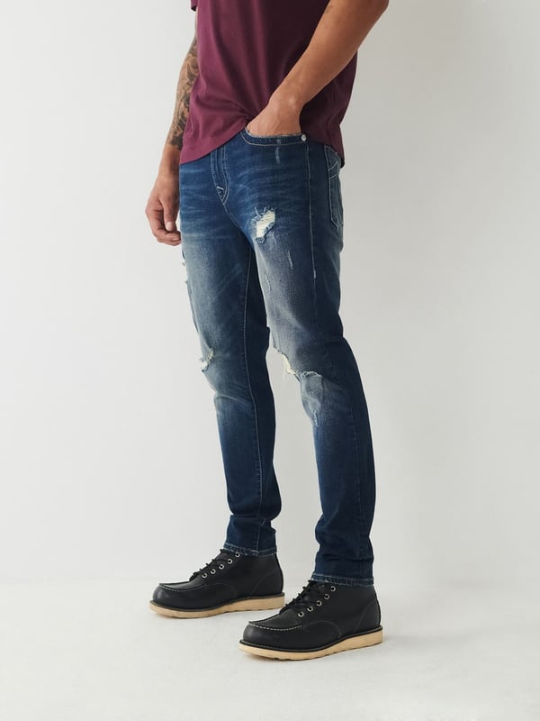 Meet our ultra-slim Jack Jean. This distressed men's super skinny jean features fading, 3D whiskering, and ripped destruction. Finished with two tone stitching, 1/2" horseshoe detailing along the back pockets, and a shorter 30" inseam.