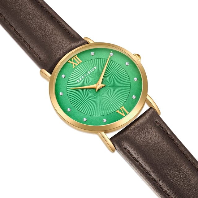 GENERAL INFORMATION:  • Targetgroup: Female  • Wristwatch: No Special Functions  • Display: analogue  • Weight of watch w/o box (gr.) - approx.: 26,0  MOVEMENT:  • Movement: Quartz  • Term of Movement: 2025  • Origin of movement: Japan  BRACELET:  • Material of bracelet/strap: Genuine leather  • Plating of bracelet/strap: None  • Finishing of bracelet/strap: Smooth  • Finishing/Decoration of bracelet/strap: Seam  • Clasp/Closure/Buckle: Buckle  • Color of bracelet/strap: Dark brown  • Length of bracelet/strap (mm) approx.: 210,0  • Width of bracelet/strap (mm) approx.: 18,0  • Style/Design of bracelet/strap: No imprint  • Bracelet/strap adjustable?: No  CASE:  • Shape of case: Round  • Size/Diameter of case in mm . approx.: 33,0  • Height of case in mm: 6,7  • Case material: Metal (Alloy)  • Surface of case: Polished  • Bezel/Topring: Fixed  • Finishing/Decoration of case: None  • Material of case back: Stainless steel  • Lock of case back: No screwed-in crown  • Color of case: Yellowgold  • Coating/Plating (Case): Ion-Plating (IP)  • Type/Form of crystal: Flat  • Material of crystal: Mineral crystal  • Water resistant (ATM): 3  DIAL:  • Size jewelry care cloth: Hour, Minute  • Indices: Roman numerals/points  • Material of dial: Brass  • Structure/pattern of dial: sunray  • Color of dial: Green  PUSHER, CROWN, HAND:  • Pusher: None  • Corrector: No  • Crown: No screwed-in crown  • Type of hands: Dauphine hands  • Luminescent (hands): No  PACKAGING & SCOPE OF DELIVERY:  • Box: Yes  • Service booklet: Yes  • Manual: Yes