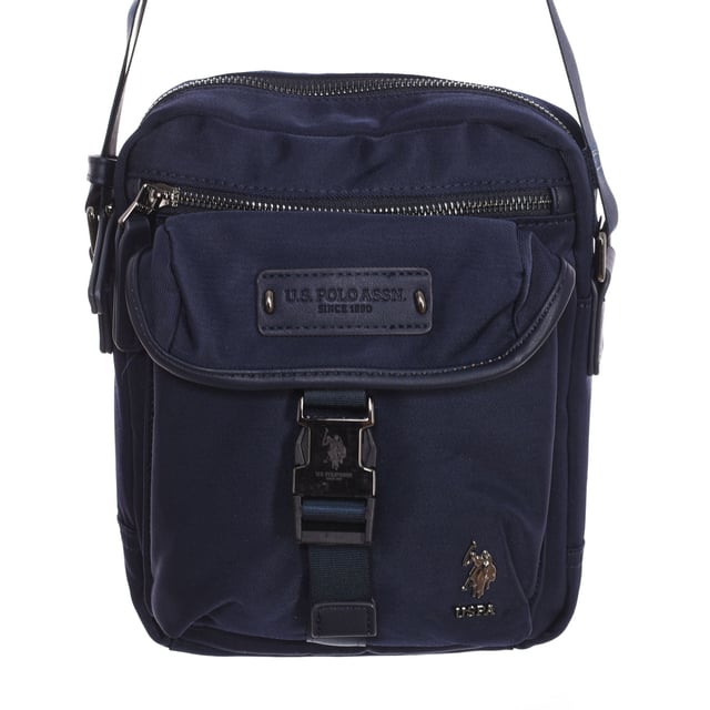 Men's shoulder bag from the U.S. POLO ASSN brand.
 Synthetic material exterior.
 Top zipper closure.
 Front Exterior: One zipper pocket and one buckle closure pocket.
 Rear exterior: One zipper pocket.
 Front interior: One zipper pocket, one open pocket and 4 pen compartments.
 Back interior: Two pockets with velcro closure.
 Adjustable strap.
 Interior lining with brand print.
 Brand logo on the front.
 Measures: 23x20x7cm
 Composition: 80% Nylon, 20% Polyurethane
 Care:
Clean with a wet cloth.