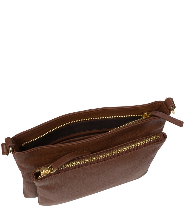 Handcrafted from super soft natural Nappa leather, the 'Jess' cross body bag from Pure Luxuries London's Marylebone Collection is a must-have thanks to the spacious design. The dual main compartments are secured with a zip-over top which opens to reveal the luxurious 10% cotton lining. Additional storage space is provided by two slip pockets in the larger compartment - ideal for maintaining an organised bag. The accessory is adorned with gold-coloured metal fittings and zips which complement the slim and adjustable leather strap with a maximum drop length of 65cm. The Pure Luxuries logo is embossed in gold foil for a beautifully simple finishing touch.