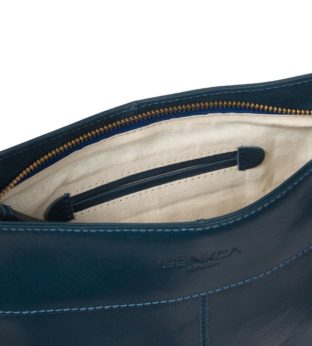 The 'Baby Bon' cross body bag from Conkca London is handcrafted from full grain genuine leather for a beautiful finish. A smaller version of the original 'Bon' cross body bag. A zip-over top conceals the central compartment that is lined with natural and untreated 100% cotton. The zipped pocket and two pockets secured with magnetic fastenings on the front of the bag, provide plentiful on-the-go storage. Comes with an adjustable fabric strap with a maximum drop length of 70cm. Adorned with the inimitable Conkca squirrel charm and embossed logo.