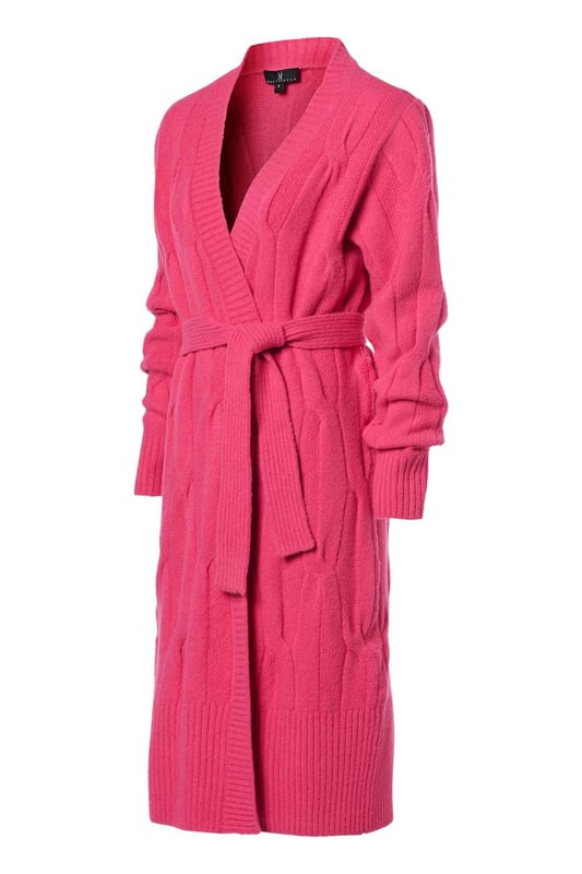 Het Chelsea kabelvest in een zachte roze kleur is een prachtig gebreid, lang vest met een openvallend ontwerp en robuuste ribboorden. Met een relaxte pasvorm die net boven de kuit valt, biedt dit vest een comfortabele en elegante uitstraling. Een afneembaar strikceintuur voegt een vleugje tailleaccentuering toe aan het geheel. Vervaardigd uit een wolmix van 47% acryl, 22% nylon, 20% wol, 8% alpaca en 3% spandex, biedt dit vest warmte en comfort, waardoor het ideaal is voor koude winterdagen. De combinatie van wol en alpaca verleent het vest een zachte en luxueuze textuur, terwijl acryl en nylon zorgen voor duurzaamheid en vormbehoud. De toevoeging van 3% spandex biedt een lichte stretch, wat resulteert in een comfortabele en flexibele pasvorm.Kortom, het lange roze Chelsea vest is een stijlvol en veelzijdig kledingstuk, met zijn losse snit, bijbehorende strikceintuur en prachtig gebreide ontwerp. De combinatie van diverse hoogwaardige materialen garandeert zowel comfort als stijl, waardoor het een uitstekende aanvulling is op je wintergarderobe. Het Chelsea vest biedt talloze mogelijkheden om verschillende stijlvolle en comfortabele outfits te creëren.Een suggestie is om het Chelsea vest te dragen over de Jesper travel top, samen met de Indy travel broek in een opvallende kobaltkleur. Het contrasterende kobaltblauw voegt een levendige dimensie toe aan het roze vest, wat zorgt voor een sprankelende outfit. Je kunt ook het Chelsea lange vest combineren met de Cassidy tuniek in een veelkleurig patroon, samen met de zwarte legging. Het levendige en kleurrijke patroon van de tuniek creëert een boeiend contrast met het effen roze vest. Eveneens kun je het roze kabelvest succesvol combineren met de Audrey print blouse. Onthoud dat jouw comfort en zelfverzekerdheid in je kledingkeuze centraal staan. De combinatie van de roze tint en het sprankelende, veelkleurige patroon geeft je outfit een krachtige en vrolijke uitstraling.