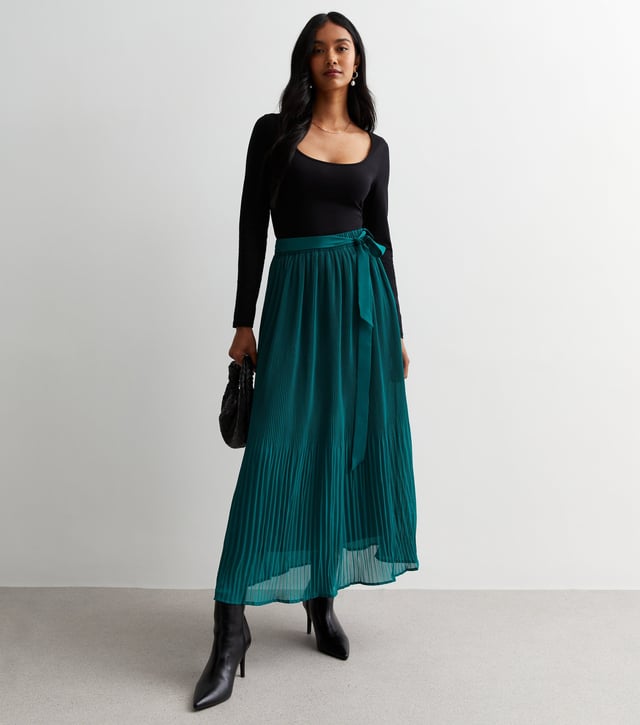 Esta falda midi plisada verde con detalle de cinturón está diseñada por expertos con un corte midi y confeccionada en un tejido vaporoso de tacto ligero con detalles de cinturón. Su silueta contemporánea es favorecedora y atemporal, perfecta para cualquier ocasión.