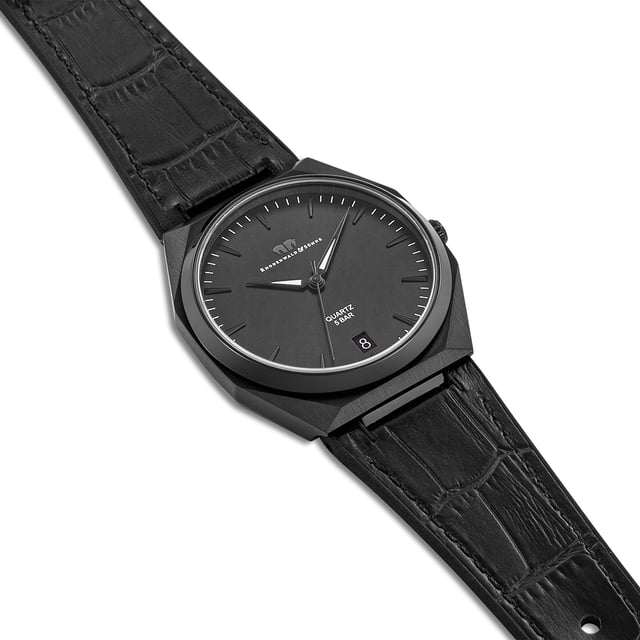 Purism in connection with classic watchmaking and stylish zeitgeist: This clock model of the Rhodenwald & Sons manufactory convinces all Horlogerie connoisseurs. The tone-in-tone color concept is consistently continued from the dial to the ion splatted stainless steel case to the real leather strap with crocodula. On the minimalist dial, strings set subtle accents with a circumferential minute show, date display and luminiscating Dauphine pointer. The robust housing with screwed floor makes the watch a durable companion in leisure and work. The exclusive equipment is completed by a long-lasting, precise quartz clock.