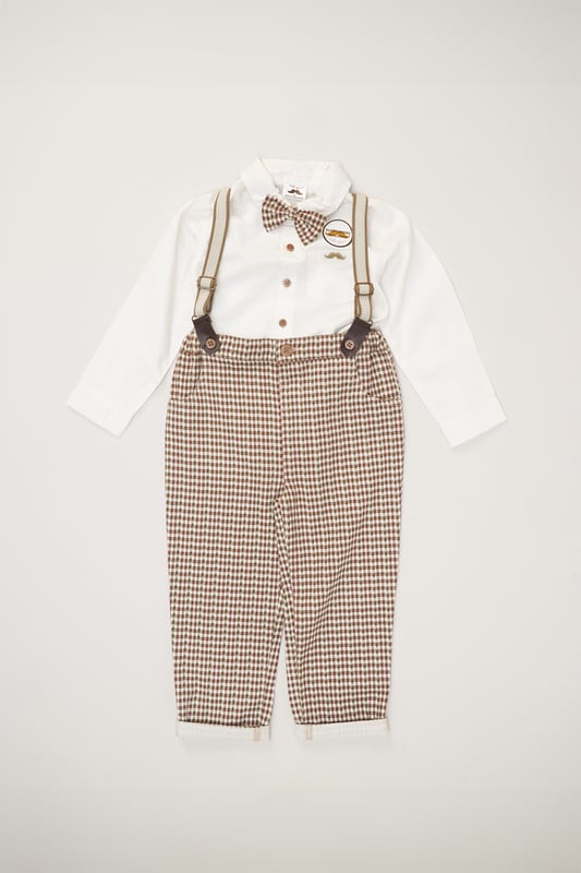 This Little Gent three-piece set features a mock shirt long-sleeved bodysuit, pair of trousers with fitted braces, and a matching bow-tie. The set is cotton with popper fastenings and cuffed legs, keeping your little one comfortable. This three-piece set from the Little Gent line is the perfect set to add a smart and comfortable look to your little ones wardrobe.